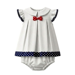 Conjunto infantil náutico de dos piezas en algodón blanco, vestido trapecio con mangas cortas y ribete de lunares azul marino, lazo rojo en el escote y borde inferior a juego. Incluye bombacho coordinado. Diseño fresco y elegante, ideal para ocasiones especiales.