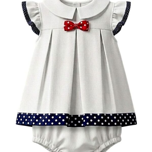 Conjunto infantil náutico de dos piezas en algodón blanco, vestido trapecio con mangas cortas y ribete de lunares azul marino, lazo rojo en el escote y borde inferior a juego. Incluye bombacho coordinado. Diseño fresco y elegante, ideal para ocasiones especiales.